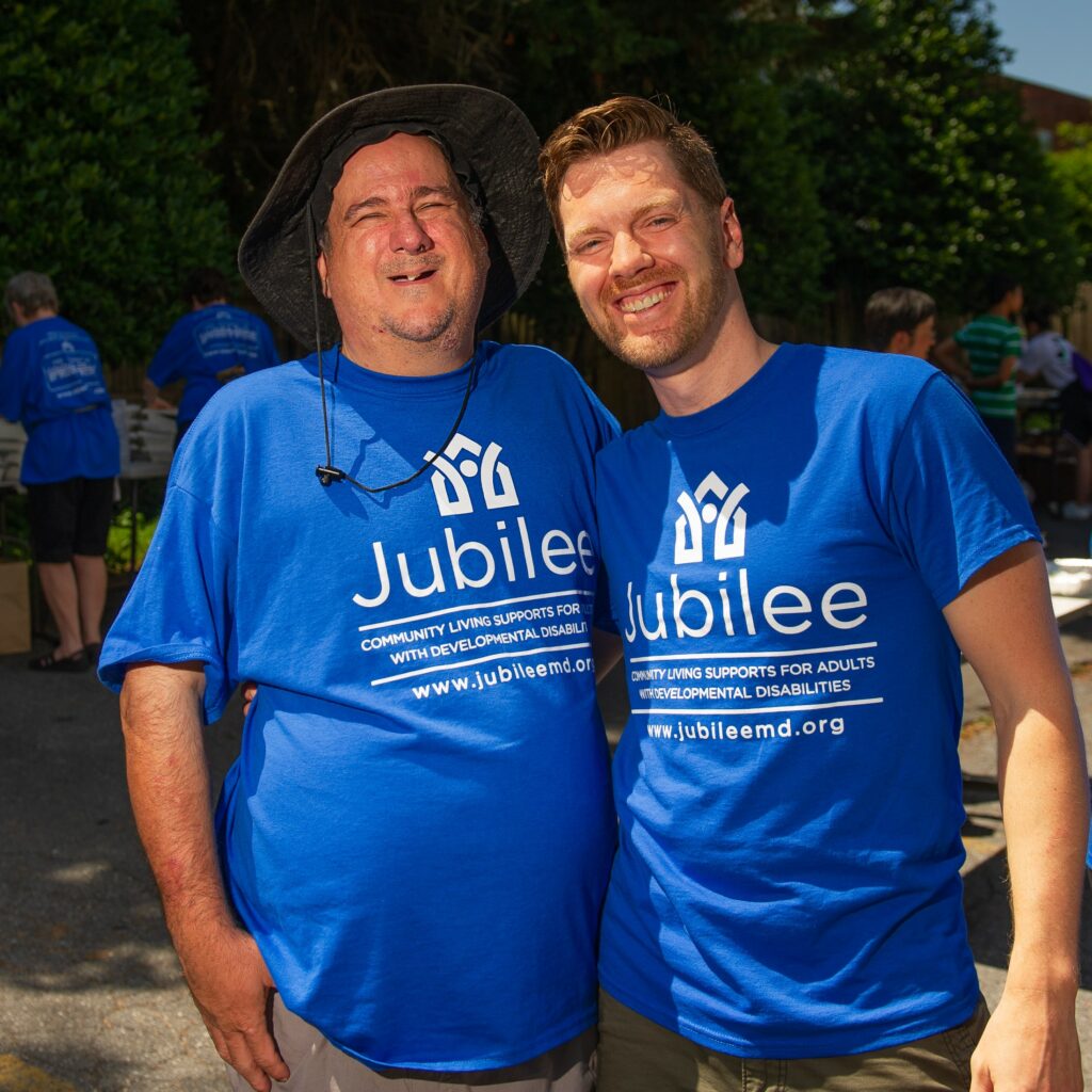 Two men smiling at camera wearing Jubilee t-shirts. 
Ben Collins and Steve Keener