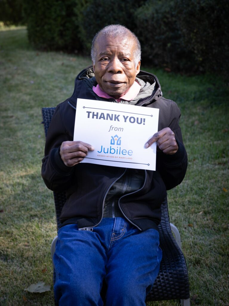 Man holding sign that reads thank you from Jubilee