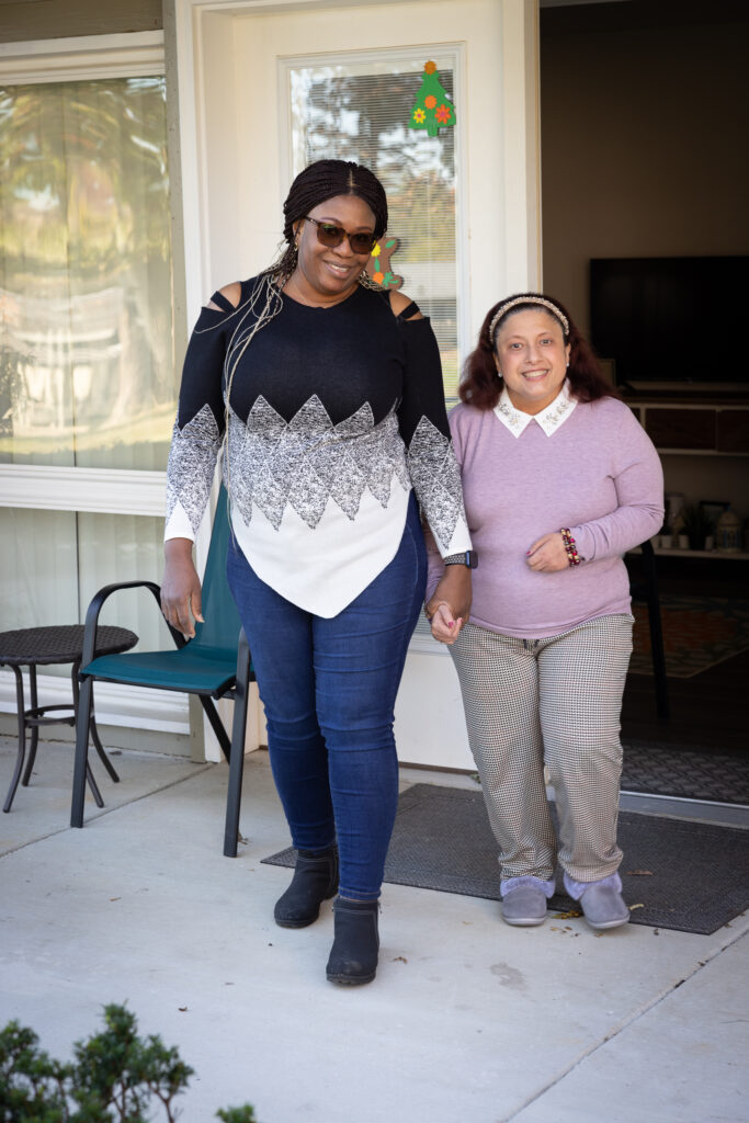 Two women stand in the doorway to an apartment home. 
Moninuola Ozoemena left and Tracy Cubas right.
